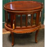 A modern teak oval tray top glazed drinks cabinet. 78cm high x 73cm x 48cm.