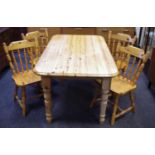 A pine kitchen table, rectangular top and four spindle back pine dining chairs