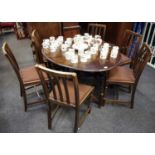 An oak drop leaf dining table and six chairs, over top barley twist supports, six lath back oak