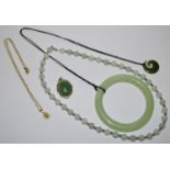 A jade bangle; a jade bead necklace; two jade pendants , one mounted etc.