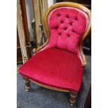A Victorian mahogany spoonback nursing chair, burgundy button upholstery, turned forelegs.
