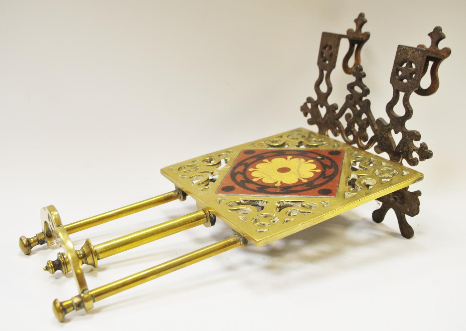 A Victorian cast iron and brass kettle stand inset with W.Godwin tile.