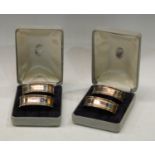 A set of four silver oval napkin rings, decorated with Greek Key borders, boxed, London