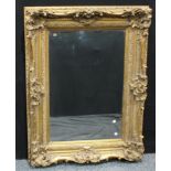 An ornate Rocco style gilt framed rectangular wall mirror, bevelled plate, 126 x 96cm overall