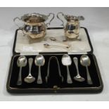 A set of six silver teaspoons, with sugar bows, Sheffield, 1929, cased; a silver cream jug and sugar