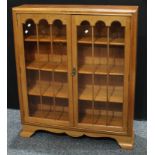 A mid 20th century oak display cabinet, a pair of glazed doors inclosing adjustable shelves. 119cm