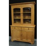 A Country house kitchen pine dresser, outswept cornice above a pair of glazed doors inclosing