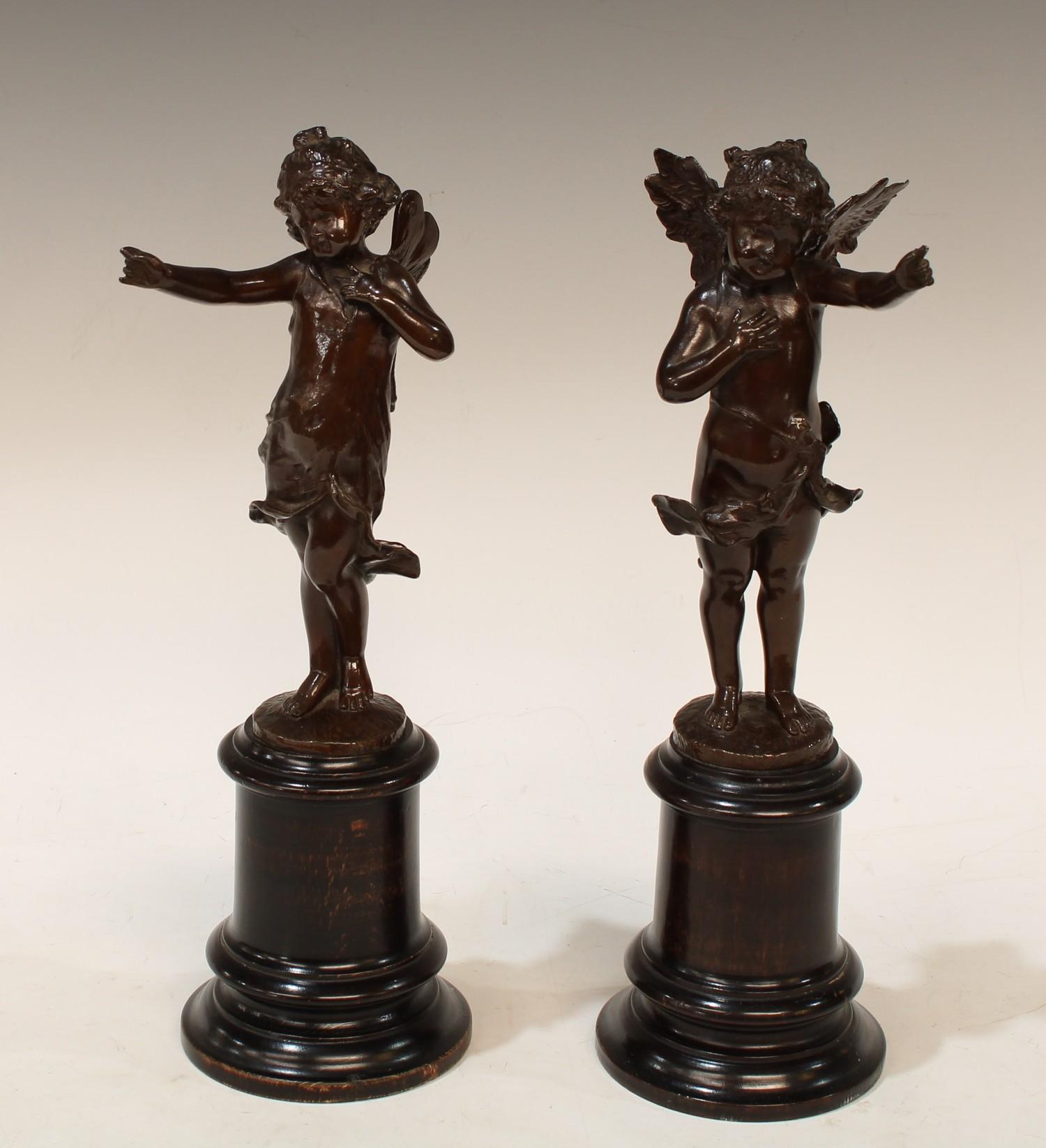 A pair of 19th century bronze figural spill vases, standing with arm raised, high ebonised