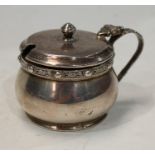 A silver Celtic band mustard pot and cover with acanthus loop handle, Birmingham 1954