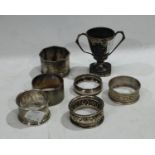 A silver napkin ring, engine turned, Birmingham 1919; four silver napkin rings, one EPNS; a
