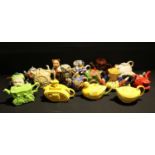 A collection of novelty teapots, including a Sadler yellow glazed teapot in the form of a tank