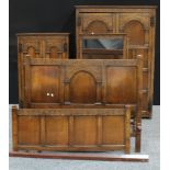 A early/mid 20th century priory oak four-piece bedroom suite, comprising two wardrobes, dressing