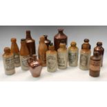 A collection of stoneware and salt glazed ginger beer bottles, including a Browne & Green Nottingham