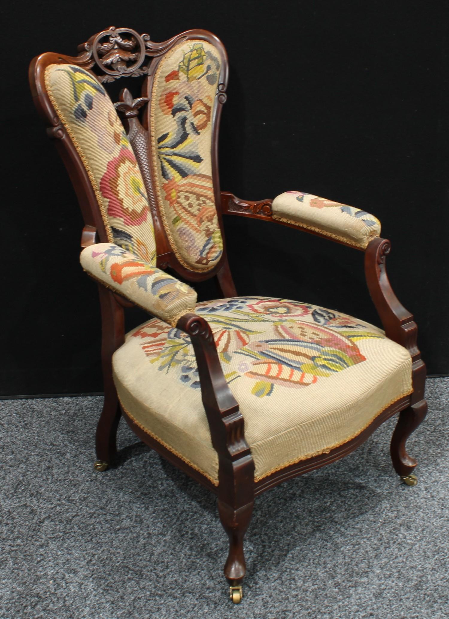 A late Victorian mahogany open armchair, butterfly-shaped back carved and pierced with a central