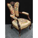 A late Victorian mahogany open armchair, butterfly-shaped back carved and pierced with a central