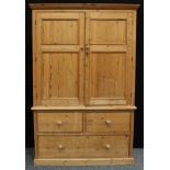 A substantial pine housekeepers cupboard, outswept cornice above a pair of panel doors enclosing a