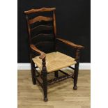 A 19th century elm ladder back armchair, shaped cresting rail, outswept arms, rush seat, turned legs