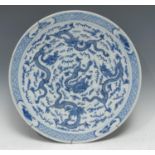 A Chinese circular charger, painted in tones of underglaze blue with ferocious dragons amongst