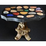 A pietra dura and bronze miniature table, the shaped serpentine top inlaid with pebble-shaped