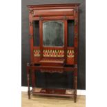 An Art Nouveau walnut hall stand, stepped cornice above a mirror and an arrangement of hat and