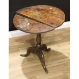 A George III oak tripod occasional table, circular tilting top, slender baluster pillar, cabriole