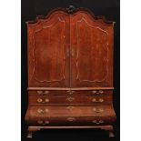 An early 19th century Dutch mahogany bombe shaped linen press, shaped serpentine cresting, above a