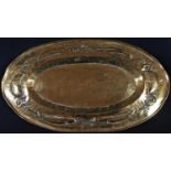 Keswick School of Industrial Art - an Arts and Crafts brass shaped oval charger, planished overall