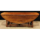An 18th century Irish style oak wake table, oval top with fall leaves, turned canon-barrel legs,