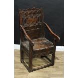 An 18th century oak Wainscot armchair, shaped back incise carved with intersecting compass-drawn