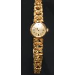 A lady's 18ct gold Omega watch, textured golden dial, baton indicators, integral 18ct gold Omega