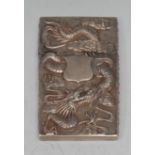 A Chinese silver rectangular visiting card case, in relief with a ferocious dragon on a densely