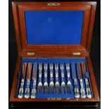 A Victorian Rococo Revival six-setting canteen of silver-hafted fruit knives and forks, the hafts