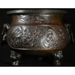 A large Chinese brown-patinated bronze tripod censer, each side cast in relief with a ferocious