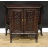 A Chinese hardwood side cabinet, beaded top above a pair of rectangular doors, profusely carved with