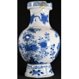 A Chinese baluster vase, painted in tones of underglaze blue with birds amongst flowering