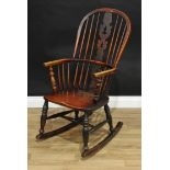 An early 19th century elm Windsor rocking chair, hooped back with shaped and pierced 'Christmas