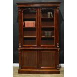 A Victorian mahogany library bookcase, outswept cornice above a pair of arched rectangular glazed