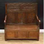 An 18th century style oak hall settle, of small proportions, the panel back carved with leafy