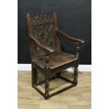 An 18th century oak Wainscot armchair, shaped rectangular back carved with flowerhead roundels and