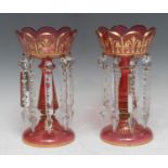 A pair of Victorian ruby lustres, applied with gilt scrolls, clear prismatic lustres, 25.5cm high,