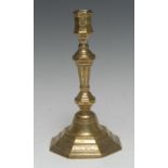 An early 18th century French brass octagonal candlestick, chased and wrigglework engraved with