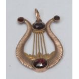 A classical garnet set Lyre pendant, textured body inset with four individually mounted round and