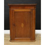 A George III oak and mahogany splay-fronted wall hanging corner cupboard, stepped cornice above a