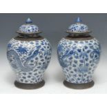 A pair of Chinese temple jars and covers, decorated in underglaze blue with dragons and foliage,