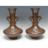 A pair of Japanese bronze two handled vases, applied in silver with geese and foliage, flared