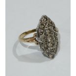 An Art Deco diamond shield panel ring, white metal shield crest inset with three central raised