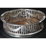 An Adam Revival silver circular coaster, pierced and engraved with a gallery of swags, draught-