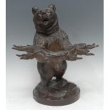 A 19th century Black Forest bear pipe holder, he stands naturalistically carved, holding a branch,
