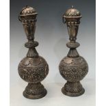 A pair of Indian Kutch silver baluster rose water flasks, domed lotus covers, profusely chased and