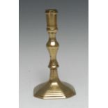A late 17th century French brass candlestick, panelled sconce, knopped stem, stepped canted square